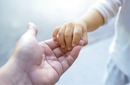 parent holding a child's hand
